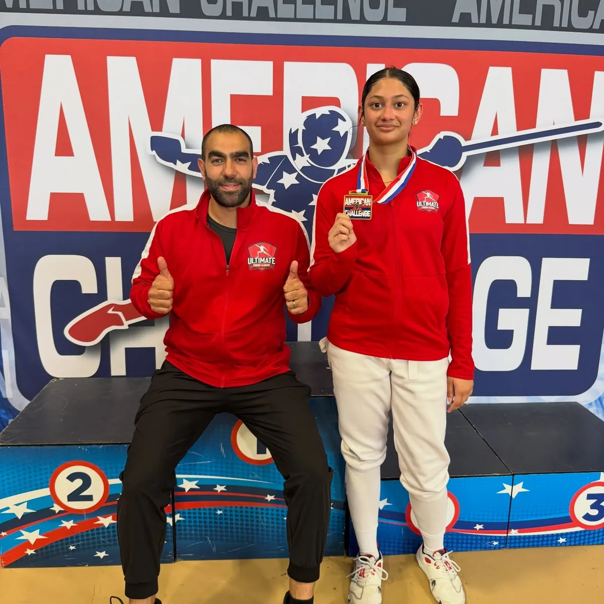 Coach Mahmoud Elshal and UFA student celebrating after earning a medal at the American Challenge national fencing championship