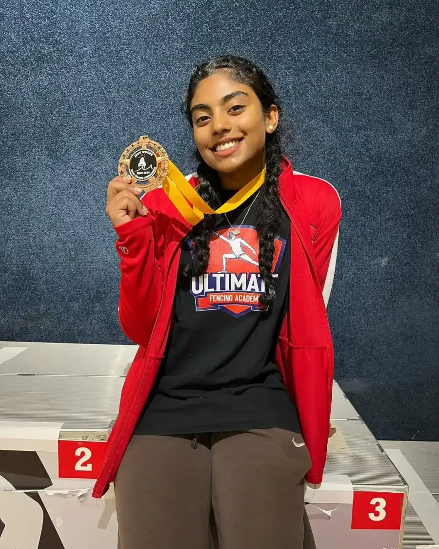 UFA student holding gold medal after tournament win