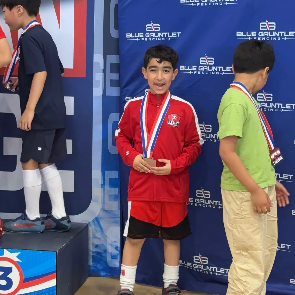 Young UFA student on the winner's podium at Blue Gauntlet Fencing national tournament